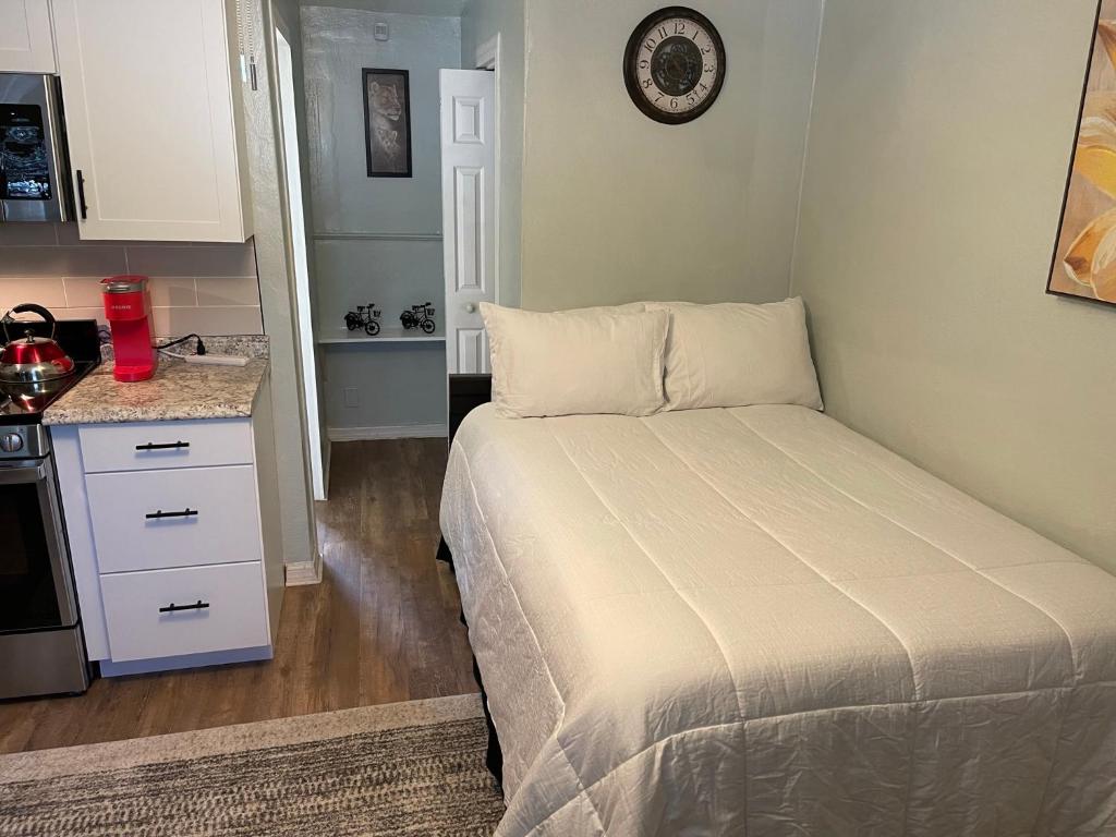 a small bedroom with a bed and a kitchen at The Quiet Sunshine Studio in Jacksonville