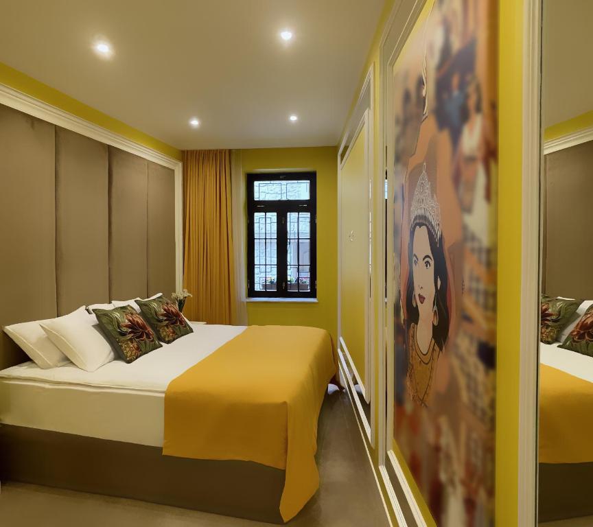a bedroom with a large bed with yellow walls at Seven Beauties Hotel Spa Restaurant, Old City Baku in Baku