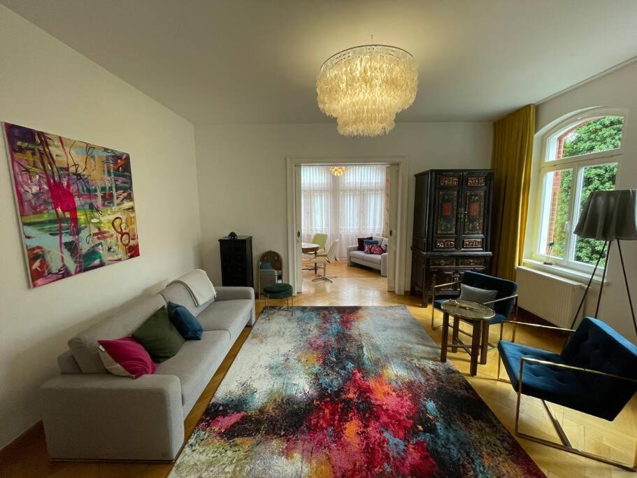 a living room with a white couch and a colorful rug at Helsinki Apartment 1 in Erfurt