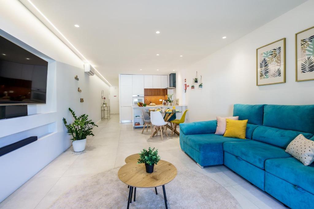 ein Wohnzimmer mit einem blauen Sofa und einem Tisch in der Unterkunft Sunny in Albufeira