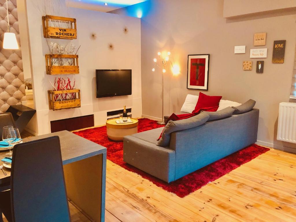 - un salon avec un canapé et une télévision dans l'établissement Chez Maïlis, à Rhisnes
