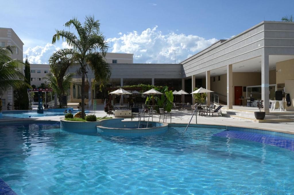 une grande piscine en face d'un bâtiment dans l'établissement Otimo apto c piscina e Wi Fi em Caldas Novas GO, à Caldas Novas
