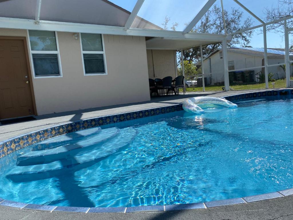 a swimming pool with a fountain in front of a house at Lovely 2 bedroom house plus a dent with private pool in North Port