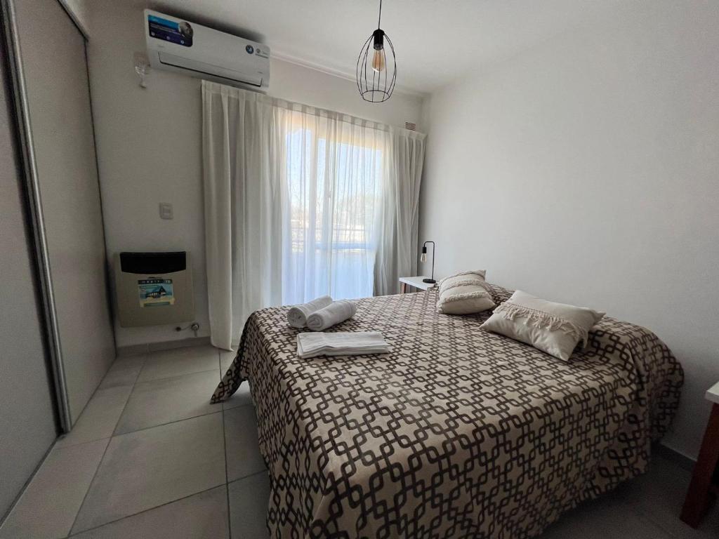 1 dormitorio con cama y ventana en Multi home en Concepción del Uruguay