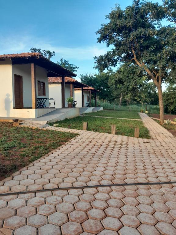 uma passarela de tijolos em frente a uma casa em Chalés por do sol em Pirenópolis