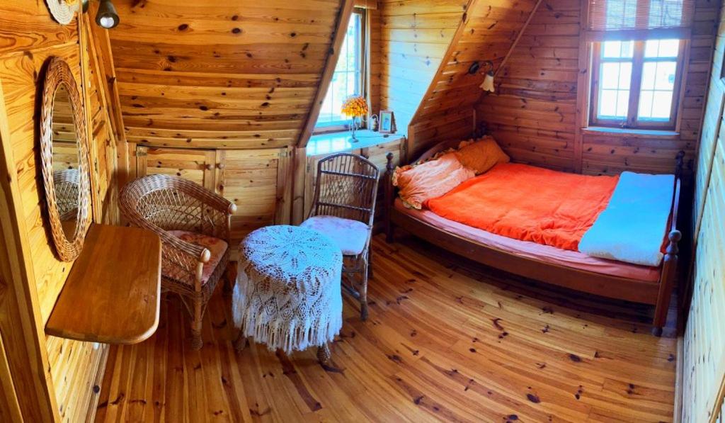 a bedroom with a bed in a log cabin at Dom Karwia in Karwia