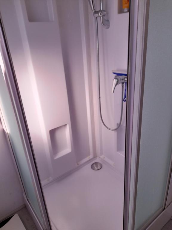 een douche in een badkamer met een glazen deur bij Jeannot in Teloché