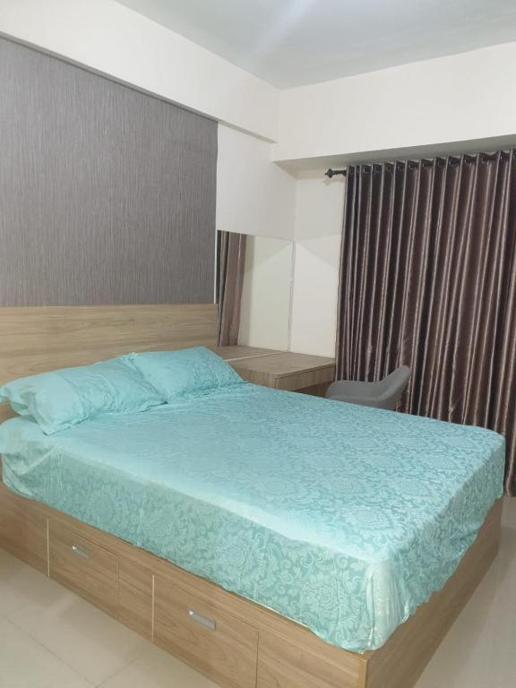 1 dormitorio con 1 cama con edredón azul en Galeri Ciumbuleuit Apartment 2 By Gezonder, en Bandung