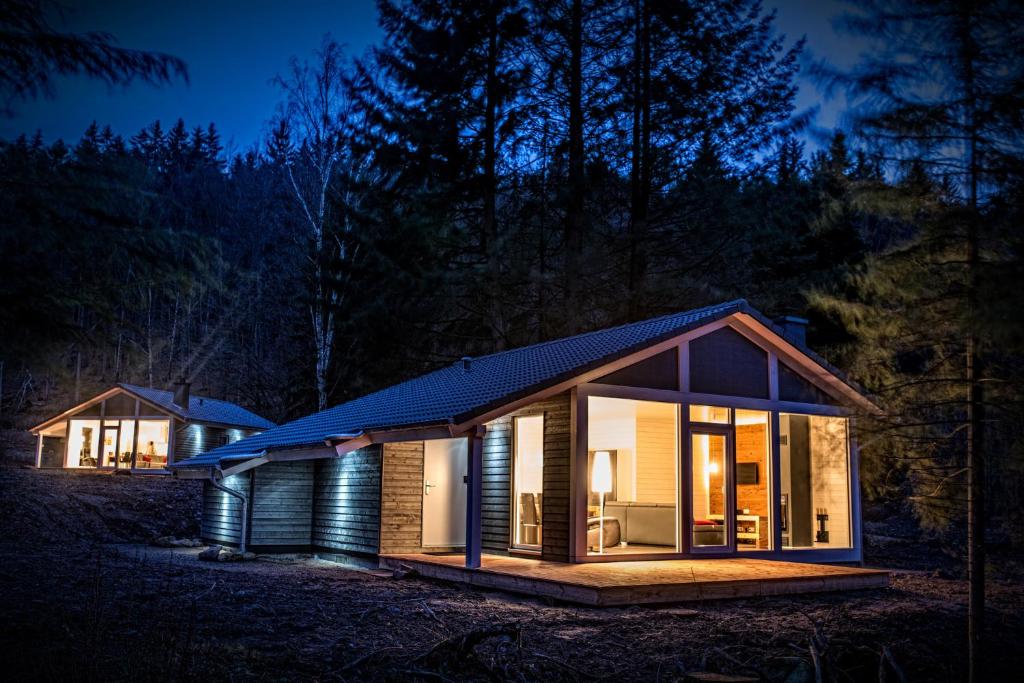 ルーラにあるFerienhaus Lichtungの夜のガラス窓のある小さな家