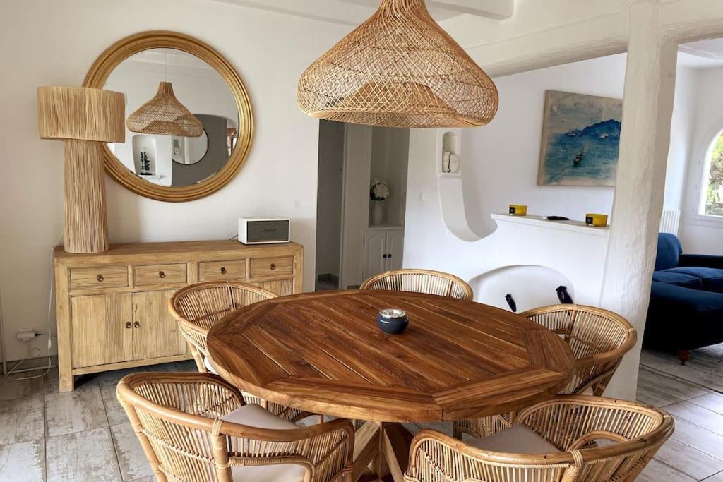 ein Esszimmer mit einem Holztisch und Stühlen in der Unterkunft VILLA LA QUIETUDE in Les Issambres