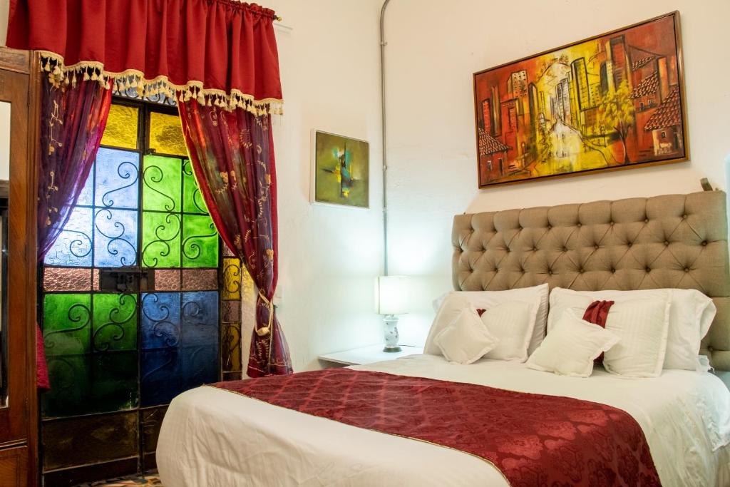 a bedroom with a bed and a stained glass window at Hotel Casa de la Luz in Bogotá