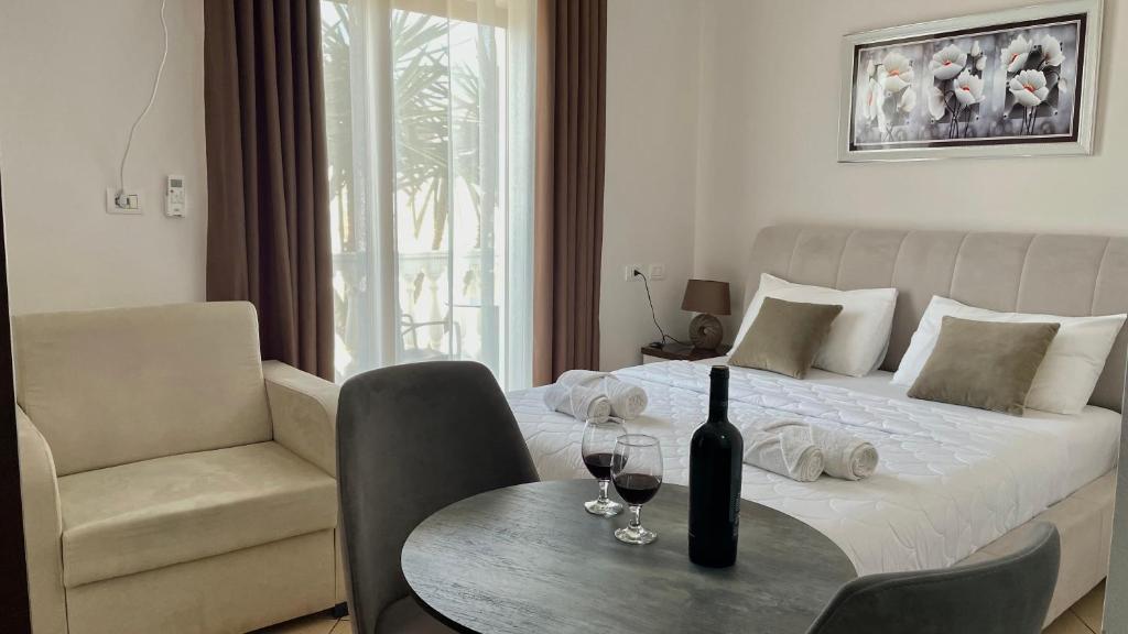 a bedroom with a bed and a table with wine glasses at Summer Dreams in Ksamil