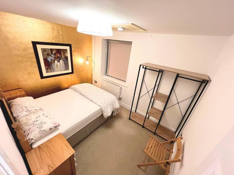 een kleine slaapkamer met een bed en een raam bij Gold Penthouse - Near Basingstoke hospital 2min in Sherborne Saint John