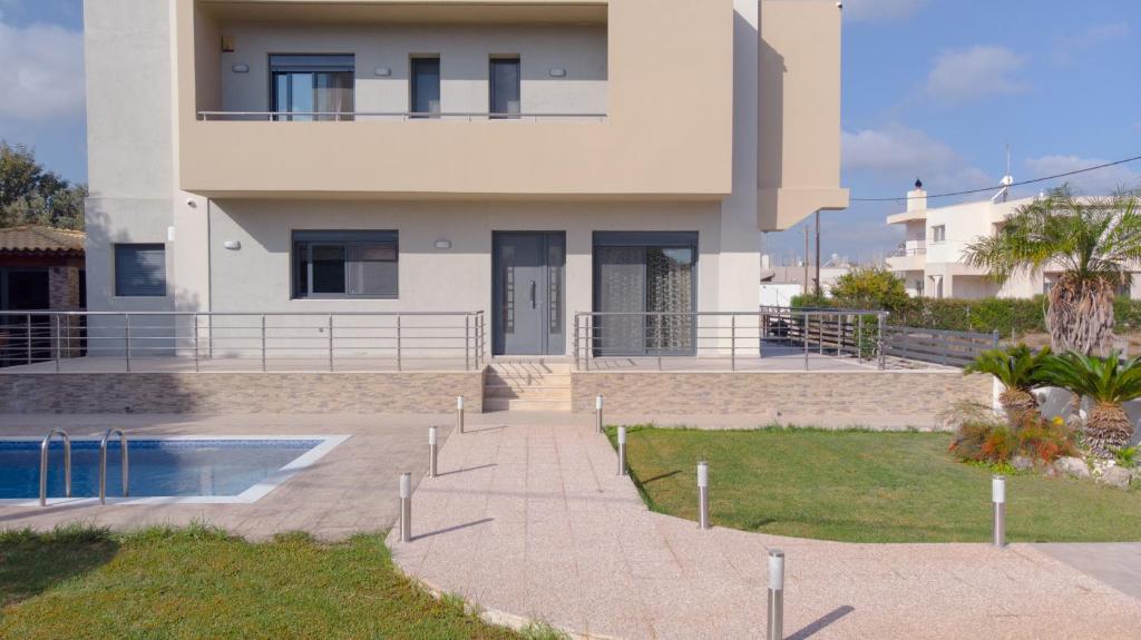 una casa con una piscina di fronte di Villa Stamatina a Pastida