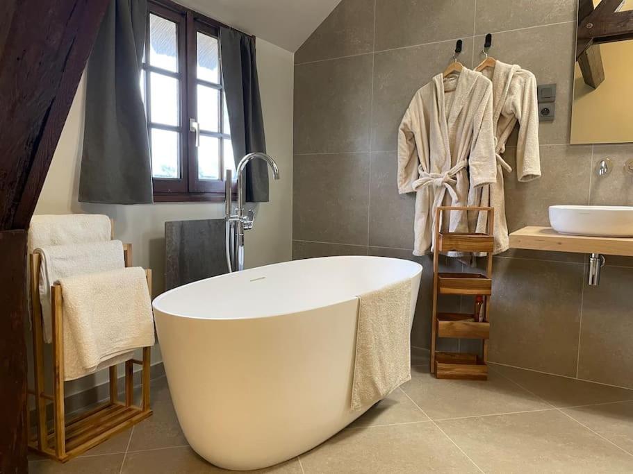 ein Badezimmer mit einer großen Badewanne und einem Waschbecken in der Unterkunft Maison haut de gamme proche de Deauville-Trouville in Les Authieux-sur-Calonne