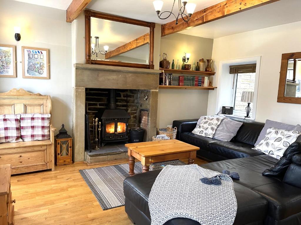 a living room with a couch and a fireplace at Mulberry Cottage with Wood Burner, Garden and Easy Parking in Haworth