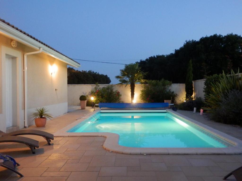 una piscina en el patio trasero de una casa en Les Chambres de PEYROUTOUS, en Pont-du-Casse