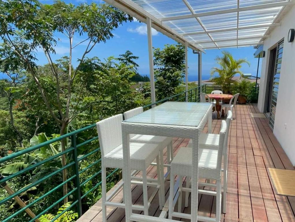 patio ze stołem i krzesłami na balkonie w obiekcie Tahiti RevaMiti EcoLodge w mieście Punaauia
