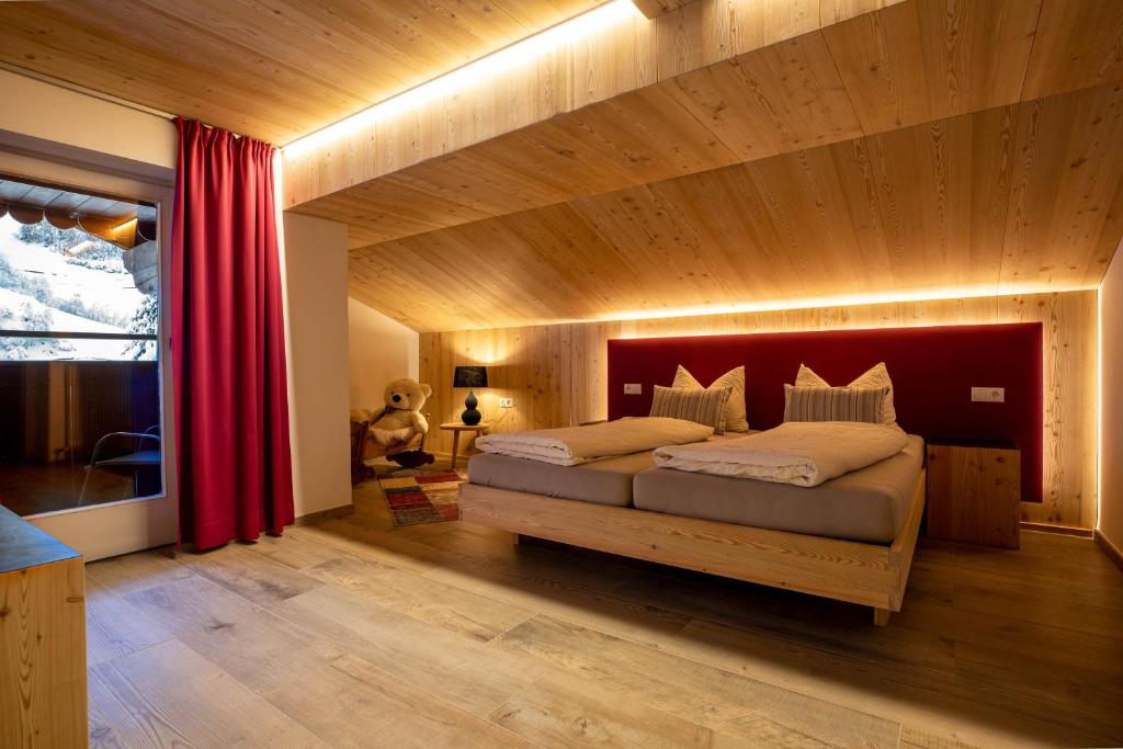 Schlafzimmer mit einem großen Bett mit einem roten Kopfteil in der Unterkunft Hotel Martellerhof in Martell