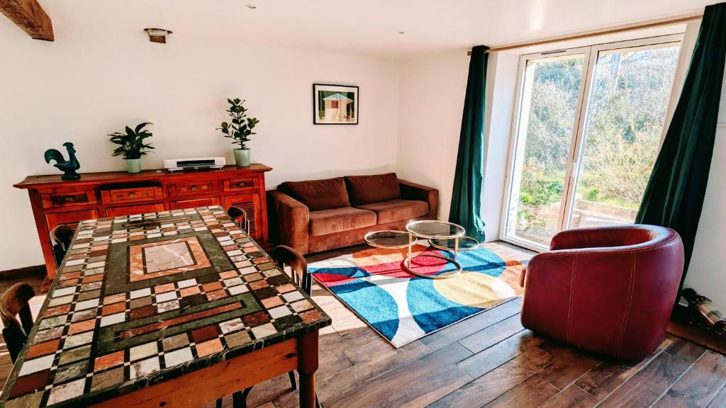 uma sala de estar com uma mesa e um sofá em Charmant gîte à la ferme em Herbignac