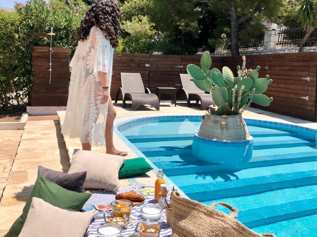 una mujer está de pie junto a una piscina en MyKosVilla with private pool, en Cos