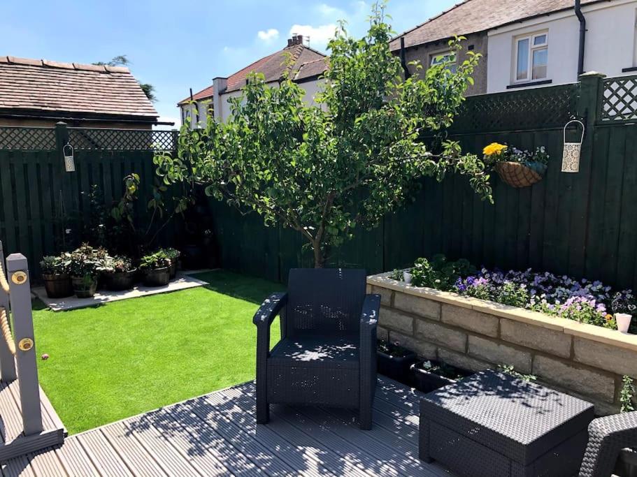 a garden with a chair and a tree in a yard at Private apartment in Wrose, Shipley, Bradford in Shipley