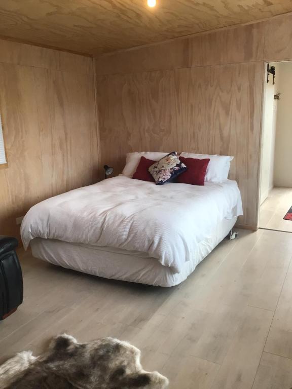 Dormitorio con cama con perro en el suelo en Brighton Beach en Dunedin