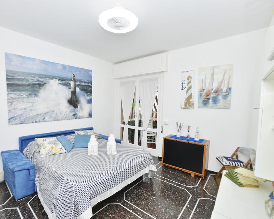 a white room with a bed and a blue chair at Appartamento Rapallo Liguria Maria Jose in Rapallo