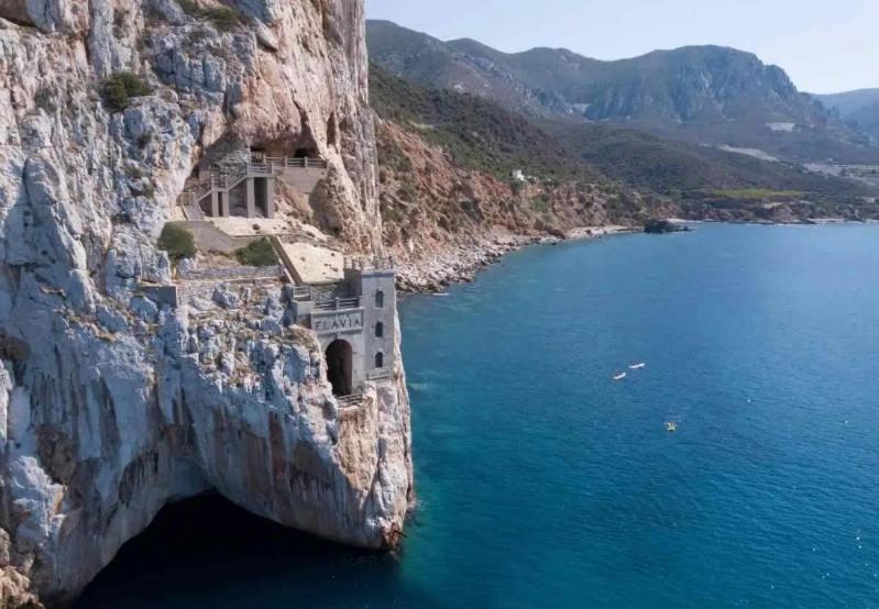 a building on the side of a cliff next to the water at Casa Margherita in Nebida
