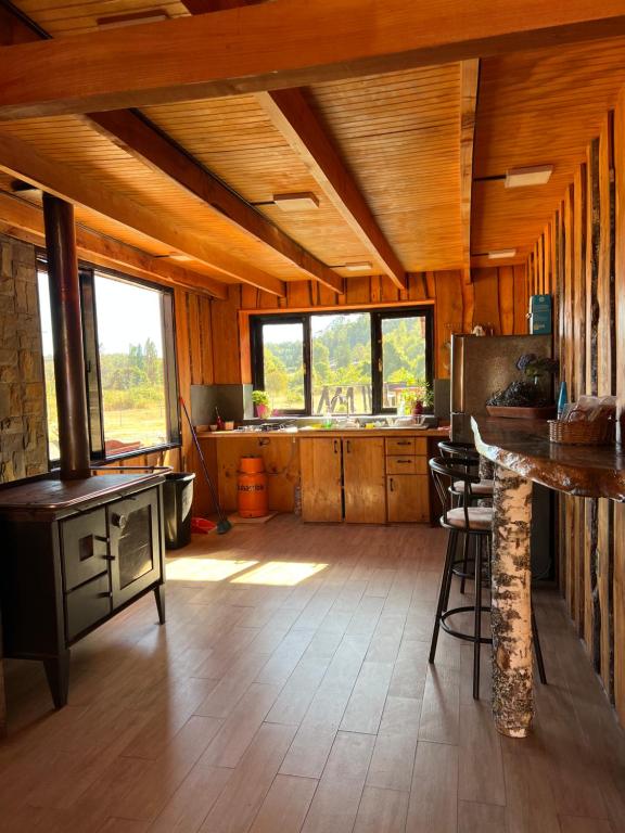a large kitchen with a stove in a cabin at Kumewe Lodge in Panguipulli