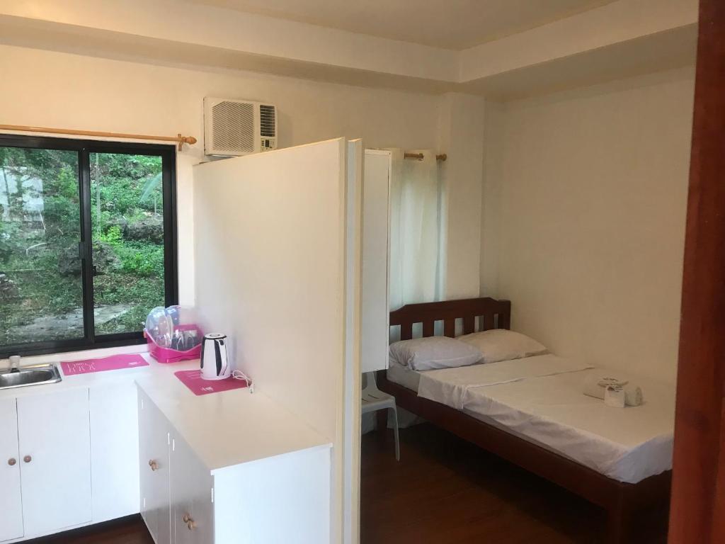 a small room with a bed and a kitchen at MLB Beachfront Apartment in Siquijor