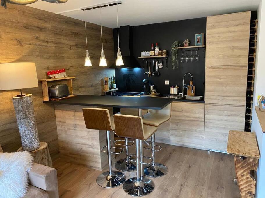 een keuken met een bar met twee krukken bij Cute duplex in Chatel centre in Châtel
