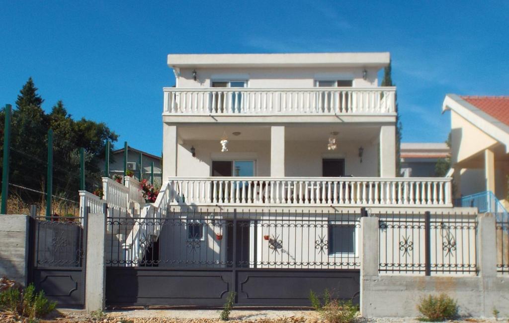 Cette grande maison blanche dispose d'un balcon blanc. dans l'établissement Adriatic Family House, à Utjeha-Bušat