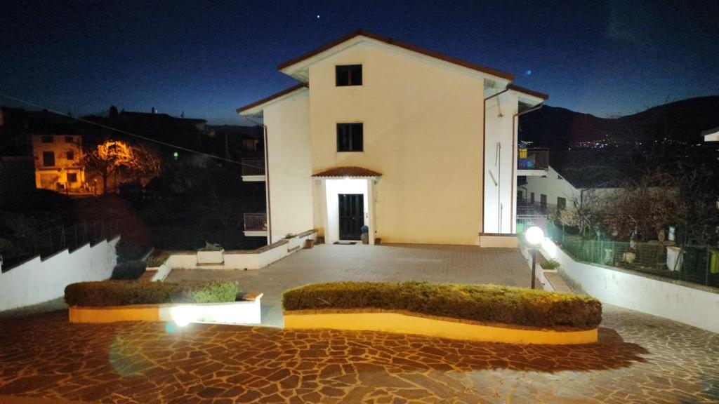 ein großes weißes Gebäude mit einem Innenhof in der Nacht in der Unterkunft Dimora del CAMMINATORE in Coppito