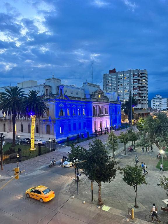 un edificio azul con un coche aparcado delante de él en Departamento Alto Gorriti en San Salvador de Jujuy