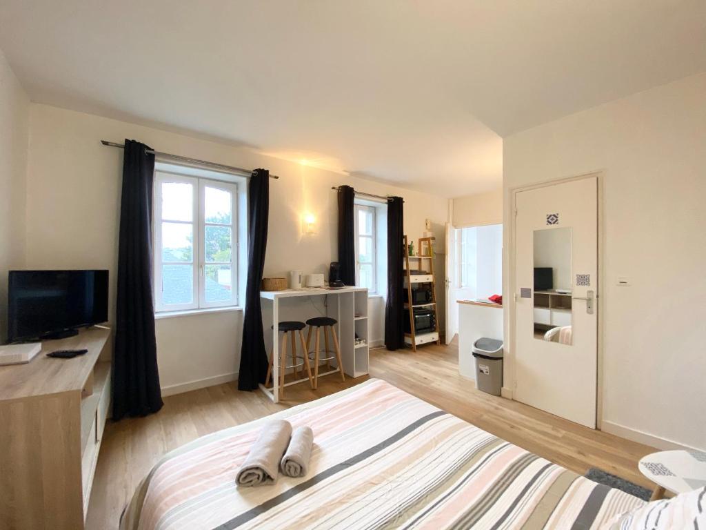 sypialnia z łóżkiem, biurkiem i telewizorem w obiekcie LE PTIT STEIR - CALME - WIFI - CENTRE VILLE - ENTREE AUTONOME w mieście Quimper