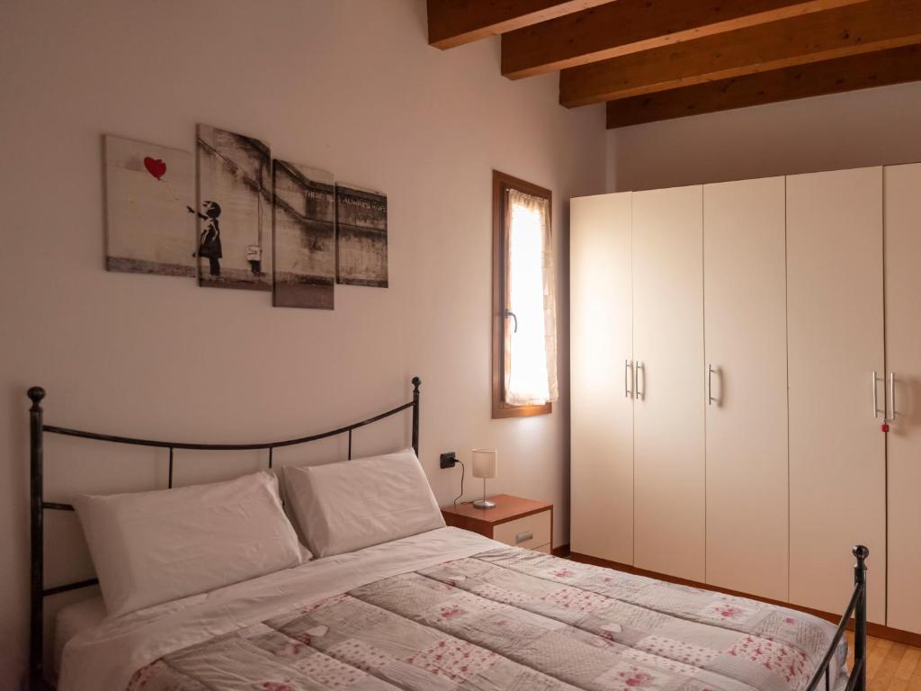 una camera da letto con un letto con armadi bianchi e una finestra di Appartamento ISOTTA a Lugo