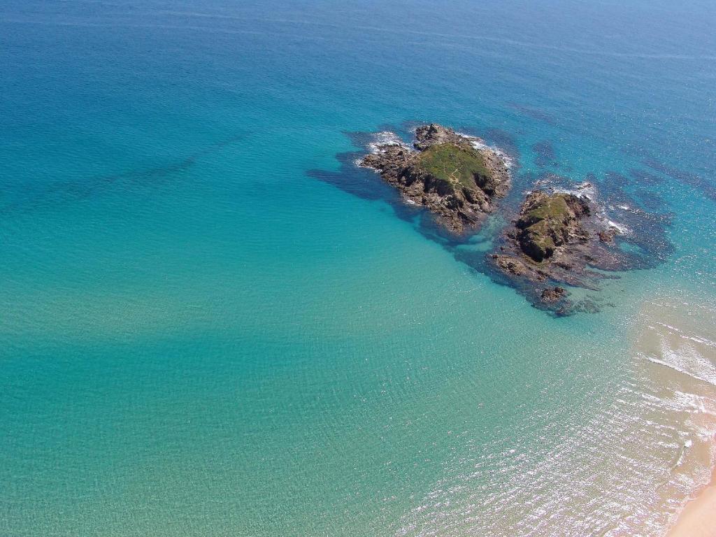 una vista aerea di una piccola isola nell'oceano di Hotel Spartivento a Chia