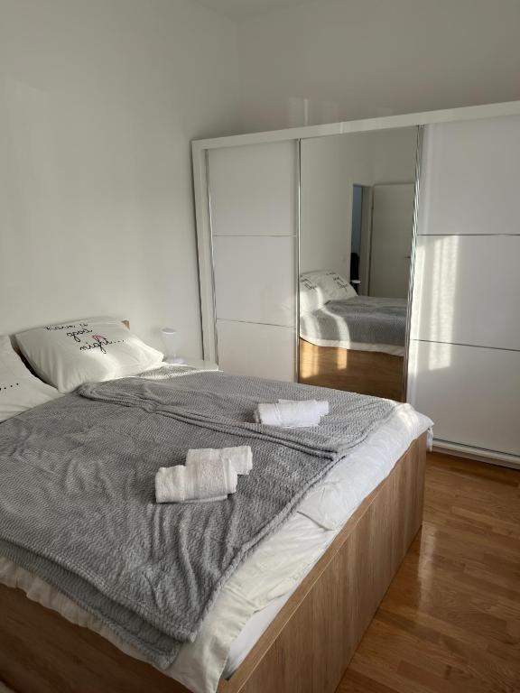 a bedroom with a large bed with two towels on it at City Rent 1 in Osijek