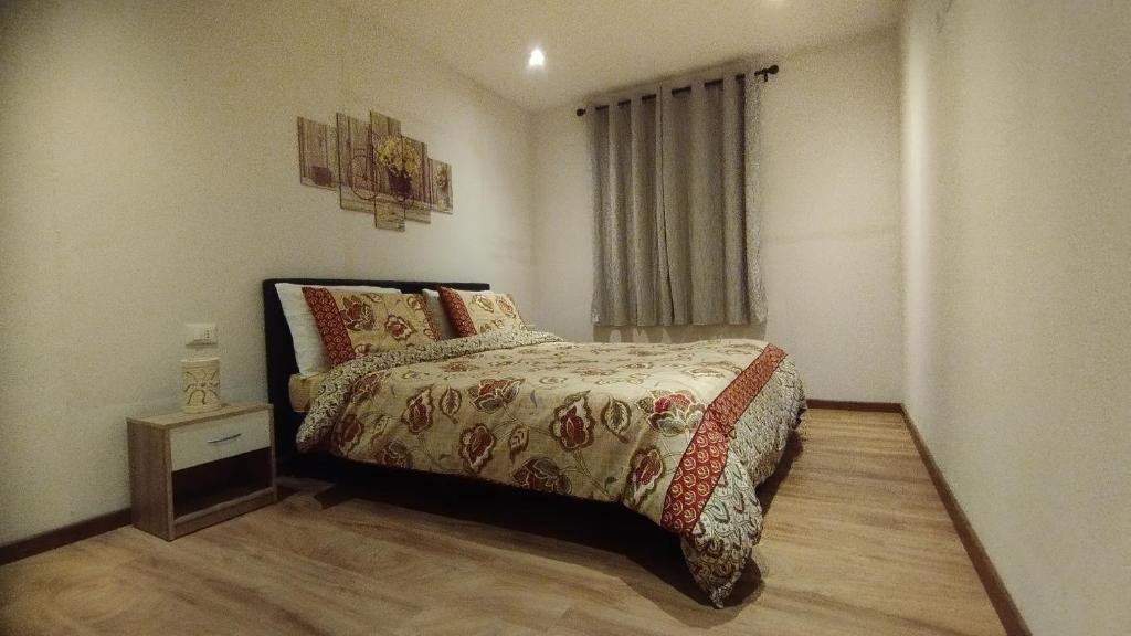 una piccola camera con letto e comodino di In centro col giardino Cipat 022147-AT-643063 a Predazzo