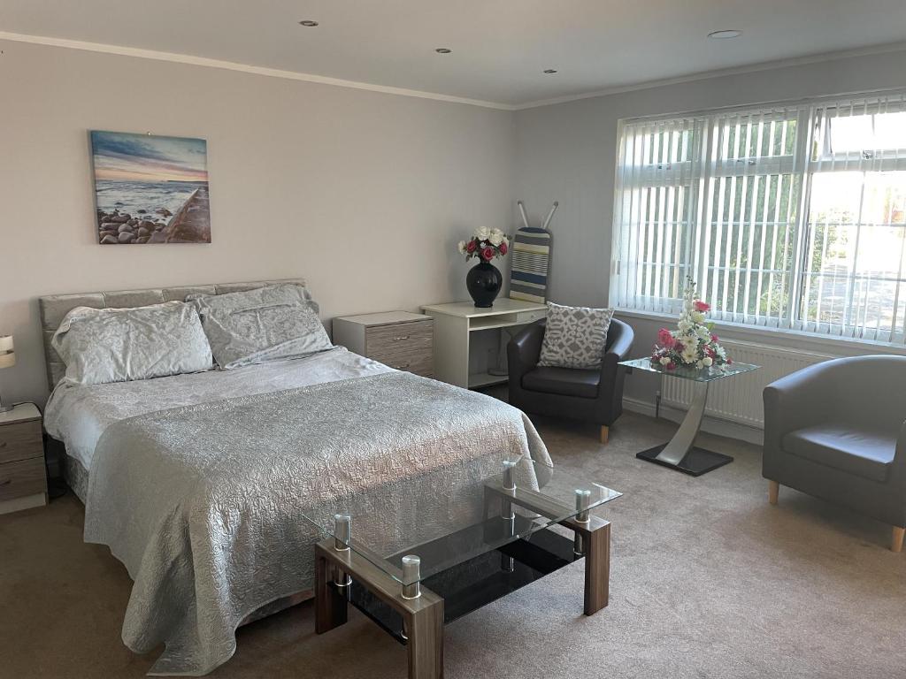 a bedroom with a bed and a chair and window at studio flat near NEC, Solihull & Airport. Short & Long stay Contractors HS2, NHS in Solihull