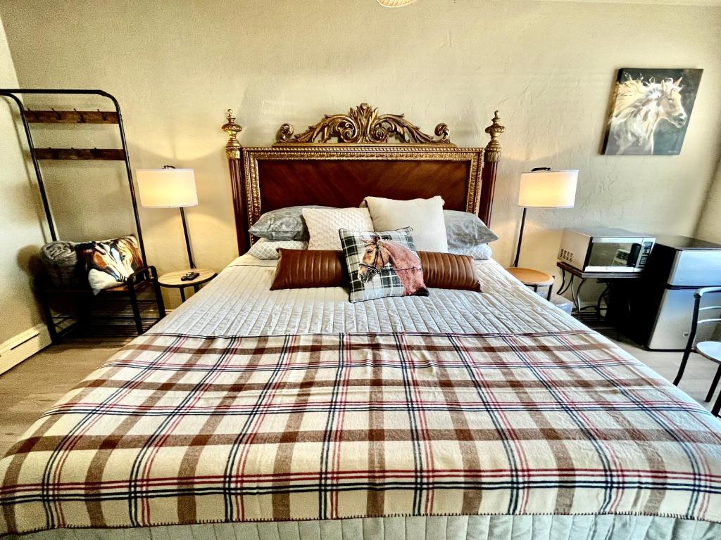 a bedroom with a large bed with a plaid blanket at Shamrock Cove Inn in Ocala