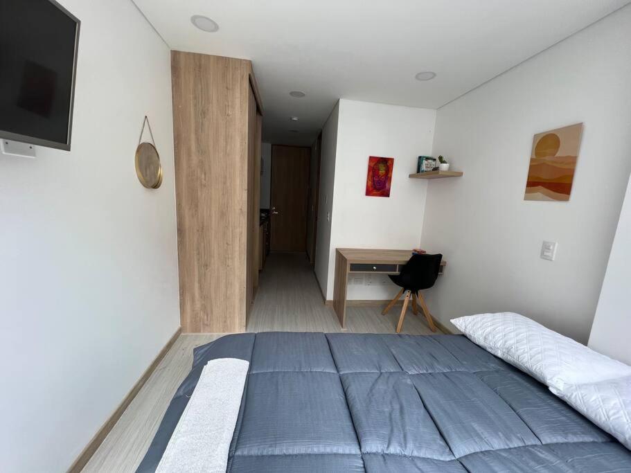 1 dormitorio con 1 cama grande y escritorio en Apartaestudio en Chapinero muy bien ubicado, en Bogotá