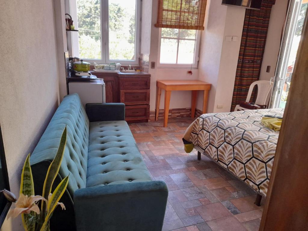 sala de estar con sofá y cama en Hosteria del Centro en Santiago Atitlán