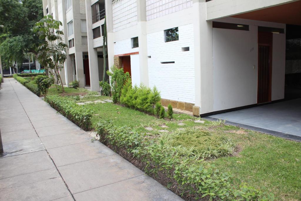 a sidewalk next to a building with a row of plants at Royalty Inn in Lima