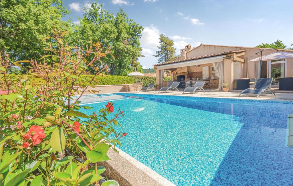 a swimming pool with chairs and a house at Villa Amelie in Saint-Cézaire-sur-Siagne