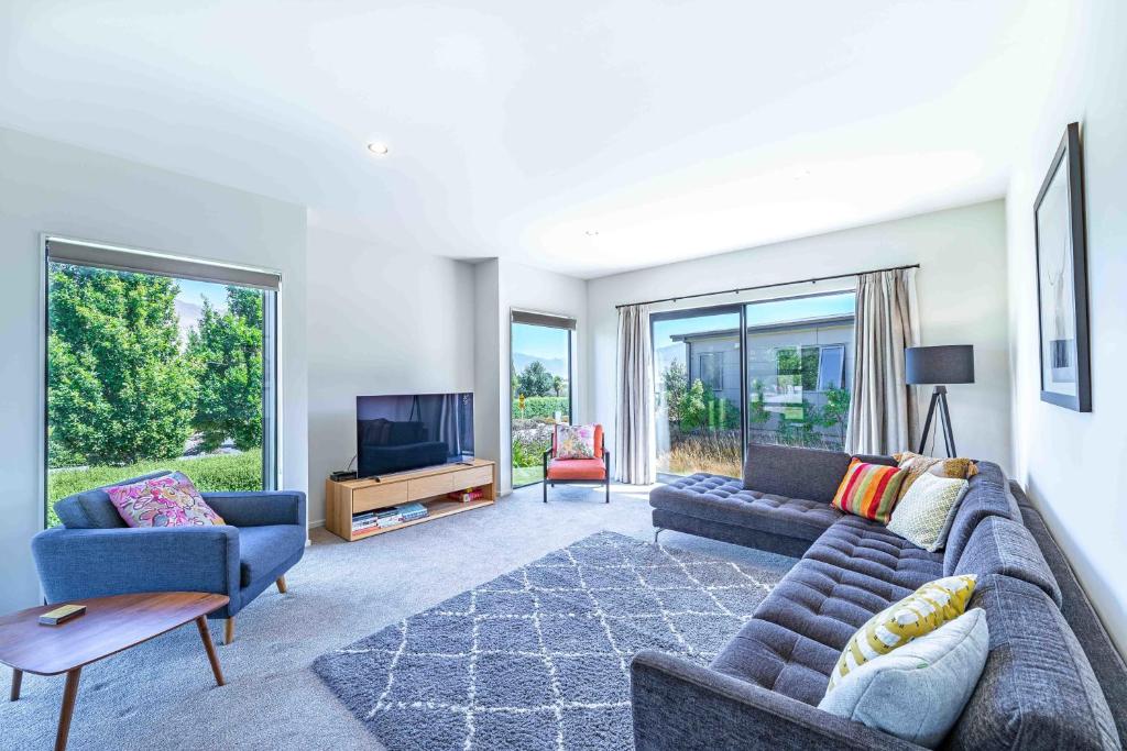 a living room with a couch and a tv at Hoheria Mountain Lodge in Wanaka