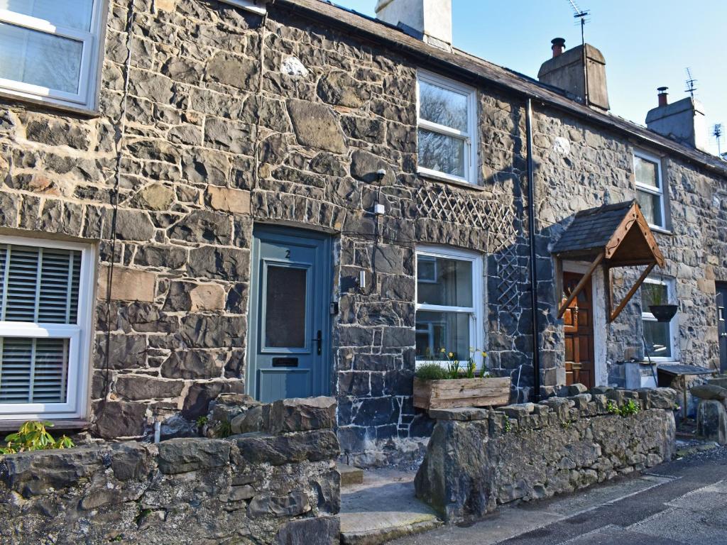 an old stone house with a blue door at Nant Y Felin in Llanfairfechan