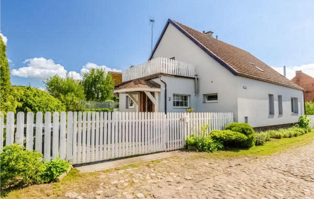 a white house with a white picket fence at 2 Bedroom Nice Apartment In Gardna Wielka in Gardna Wielka