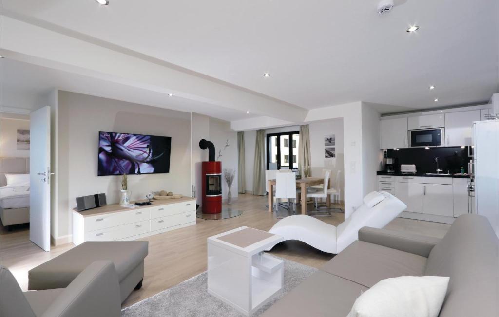 a living room with white furniture and a kitchen at Garden Suite in Binz